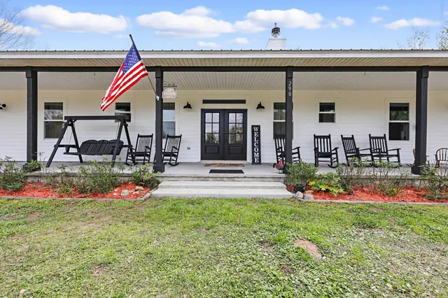 a dining room with wooden floor a chandelier a wooden table and chairs
