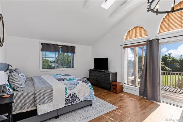 a bedroom with a bed and a flat tv screen on dresser