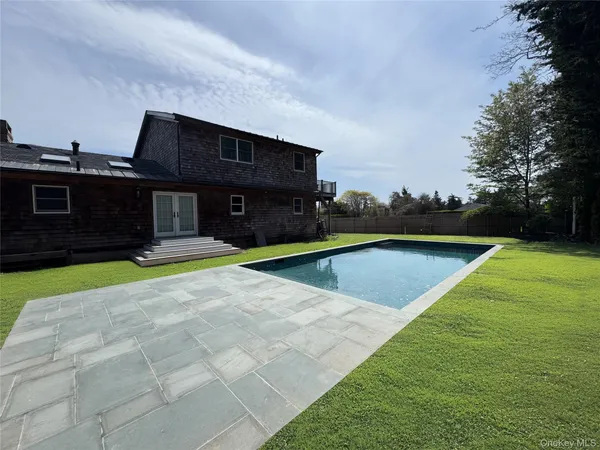 a swimming pool with outdoor seating and yard