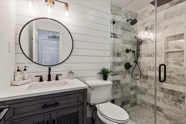 a bathroom with a sink a toilet and shower