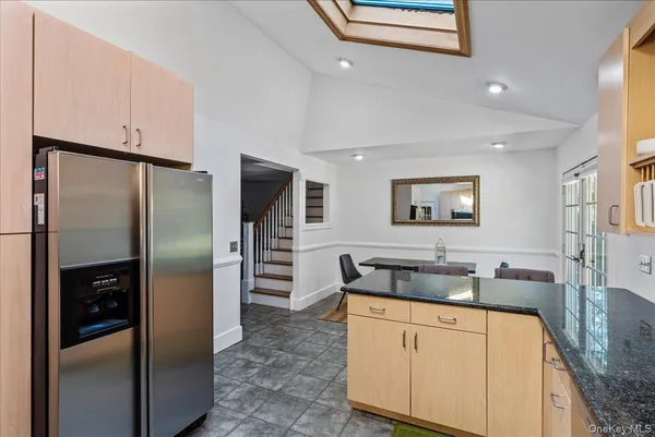 a kitchen with stainless steel appliances granite countertop a refrigerator and a sink