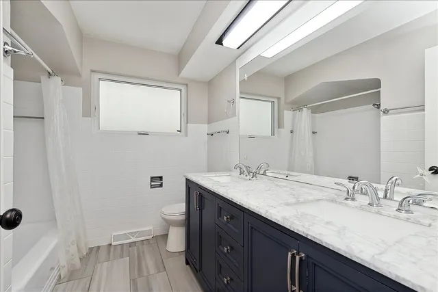 a bathroom with a granite countertop sink a mirror and a toilet