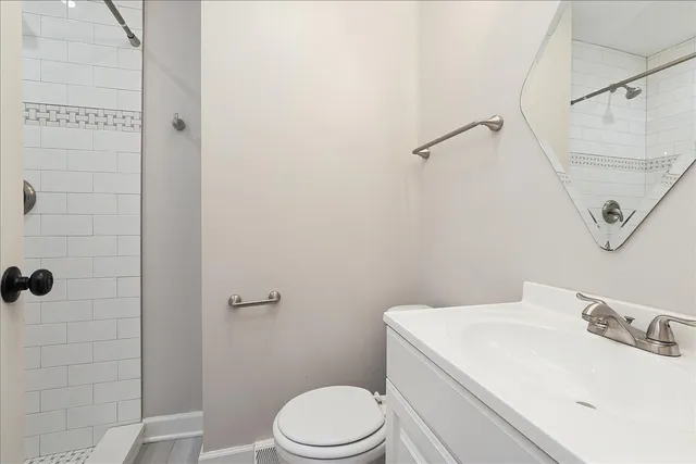 a bathroom with a sink a toilet and shower