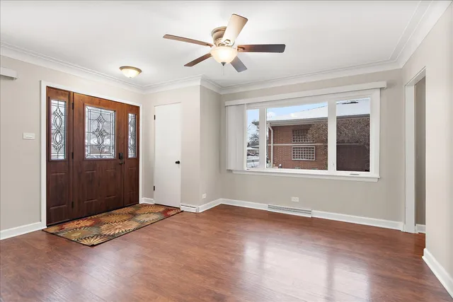a view of an empty room with window and wooden floor