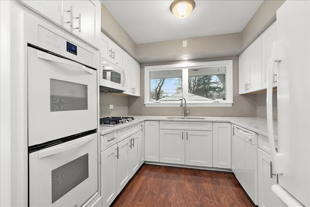 a kitchen with stainless steel appliances granite countertop a stove and white cabinets