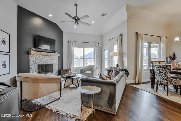 a living room with furniture a flat screen tv and a fireplace