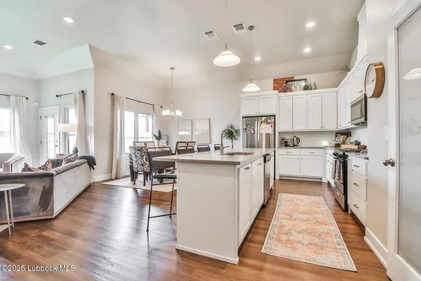 a kitchen with white cabinets and sink