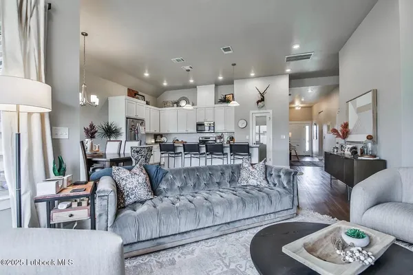 a living room with furniture and a view of kitchen