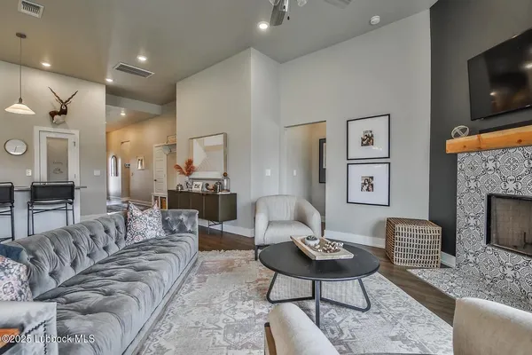 a living room with furniture a flat screen tv and a fireplace