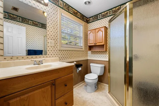 a bathroom with a toilet sink a mirror and shower