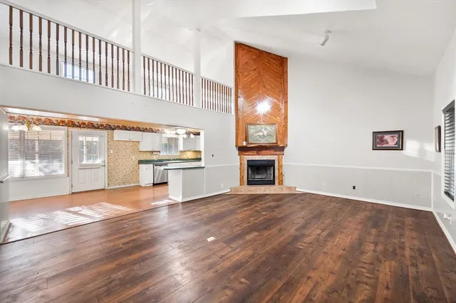 a view of empty room with wooden floor and fireplace