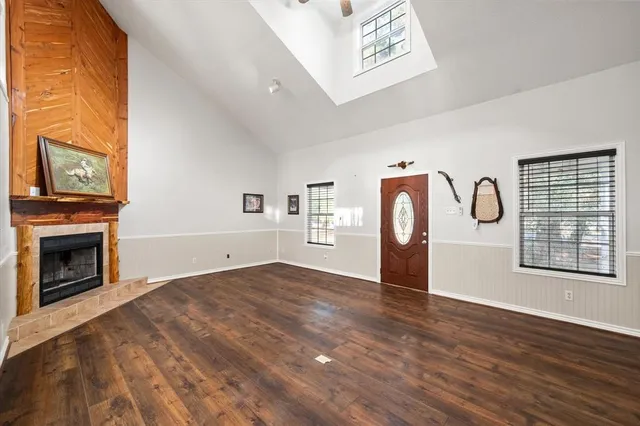 a view of an empty room with window and wooden floor