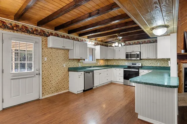 a kitchen with granite countertop wooden floors and white stainless steel appliances