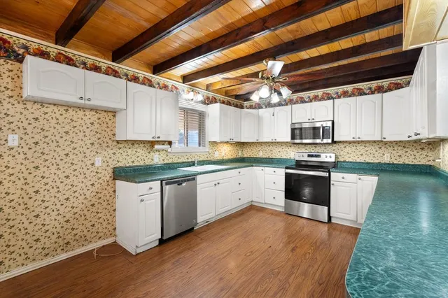 a kitchen with stainless steel appliances granite countertop a stove a sink and a microwave