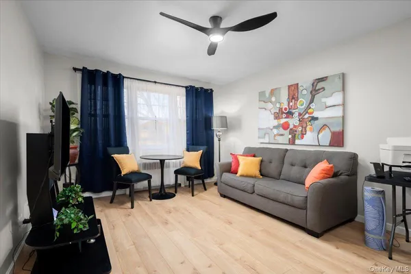a living room with furniture a flat screen tv and a window
