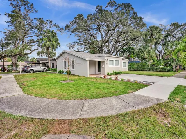 a front view of a house with a yard and trees