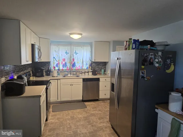a kitchen with refrigerator and cabinets