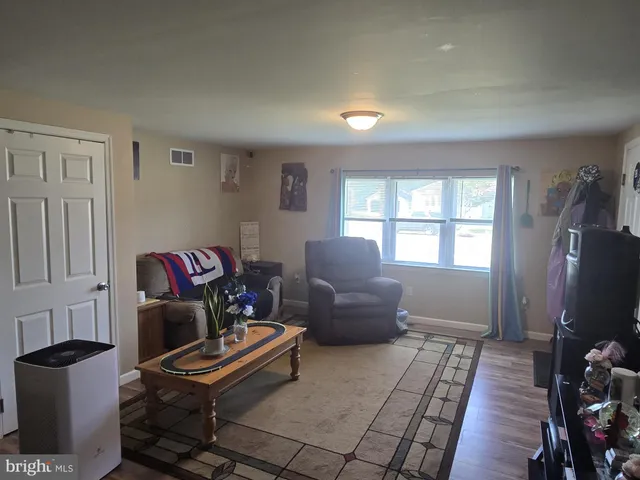a living room with furniture a window and a flat screen tv