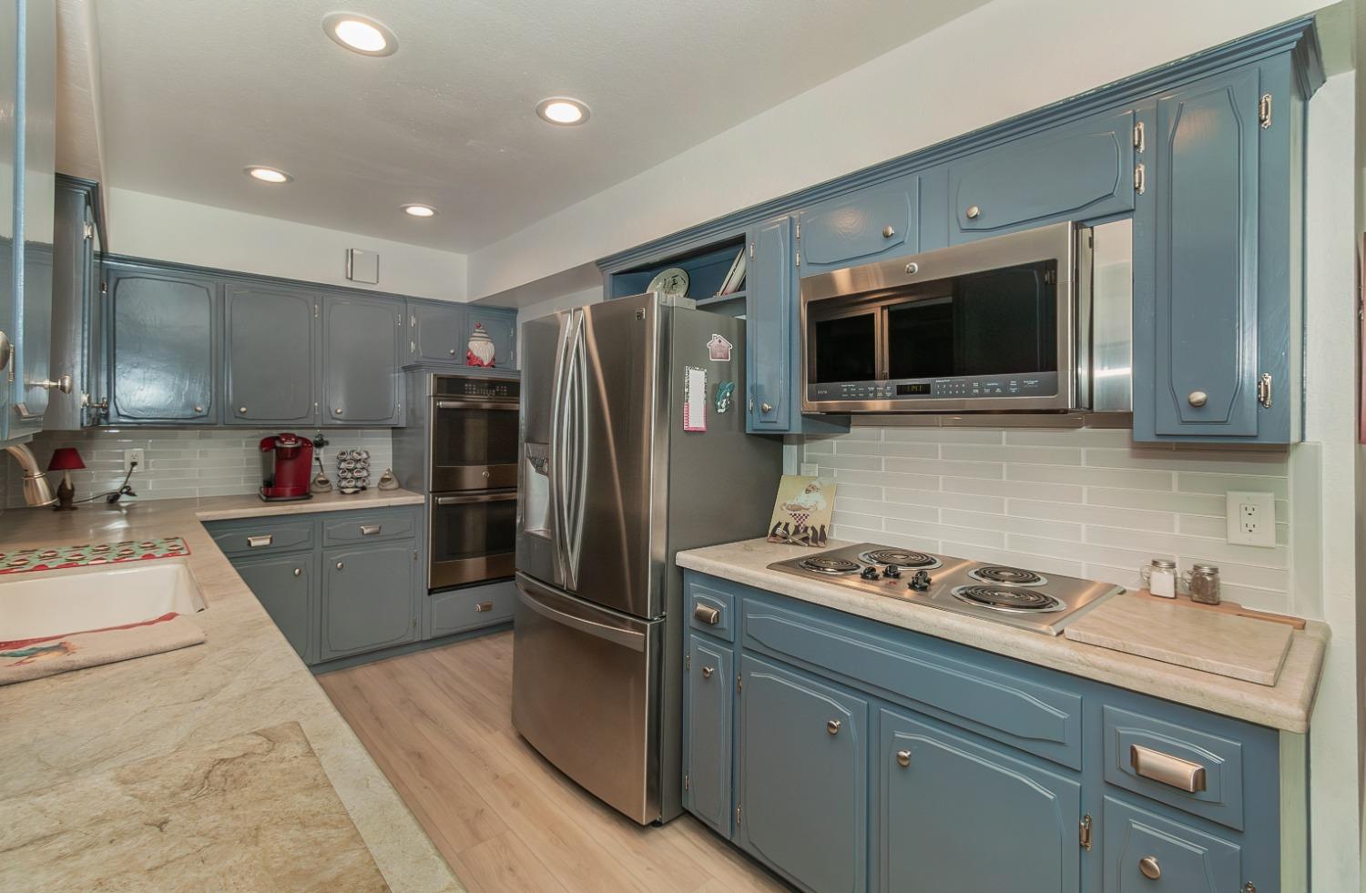 1930 Cougar Lane Clovis, CA 93611 - Photo 13 of 34 a kitchen with stainless steel appliances granite countertop a refrigerator stove microwave and sink