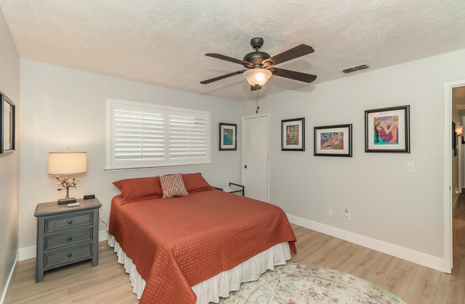 1930 Cougar Lane Clovis, CA 93611 - Photo 27 of 34 a bedroom with a large bed and a chandelier