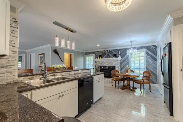 a kitchen with a refrigerator a stove top oven a sink and cabinets