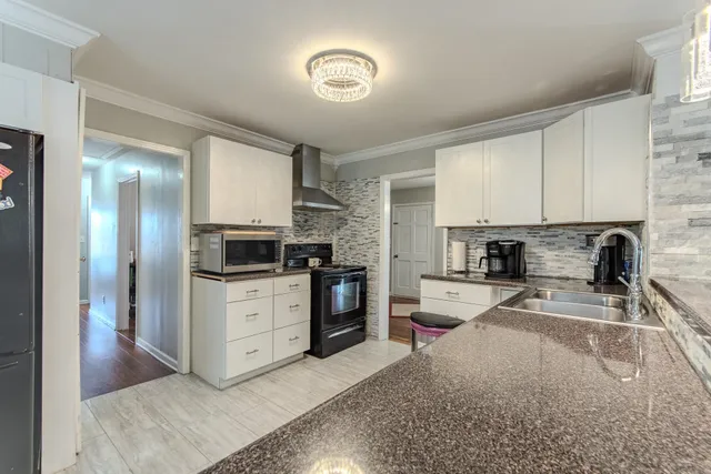 a kitchen with a refrigerator a stove top oven a sink and cabinets