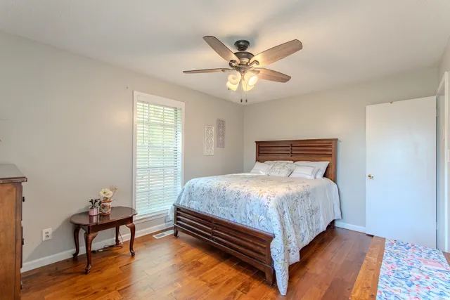 a bed sitting in a bedroom next to a window with a chandelier