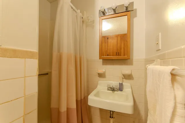 a bathroom with a sink a mirror and shower curtain