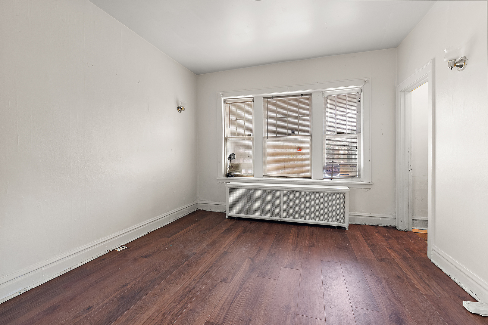 7431 South Perry Avenue Chicago, IL 60621 - Photo 4 of 14 an empty room with wooden floor and a window