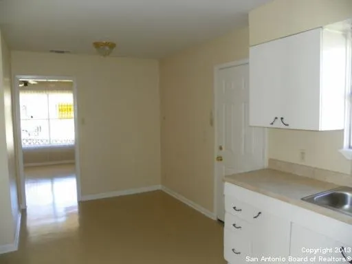 a kitchen with a wooden floor and cabinets