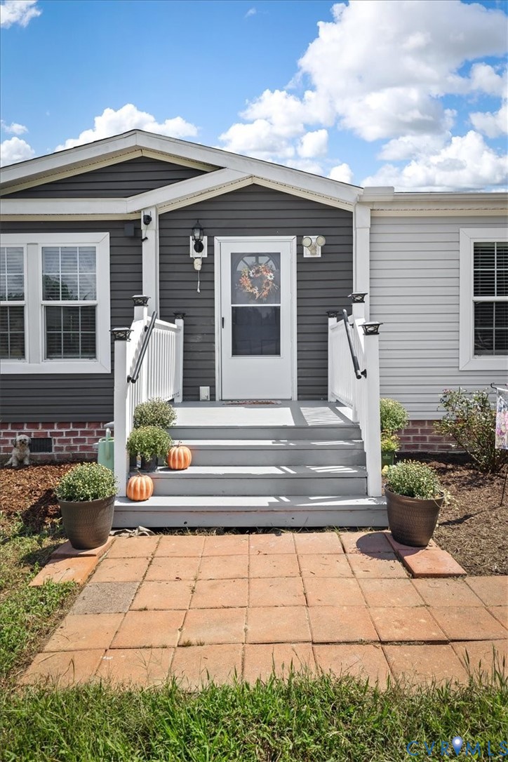 Entry with multi-tone siding and a gabled porch ro