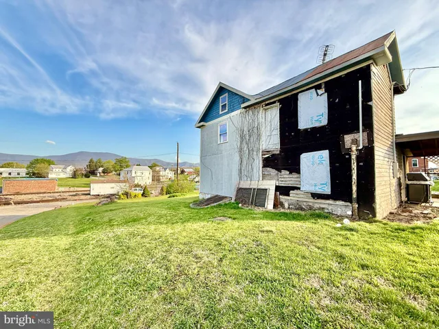 a view of a house with a big yard and large trees