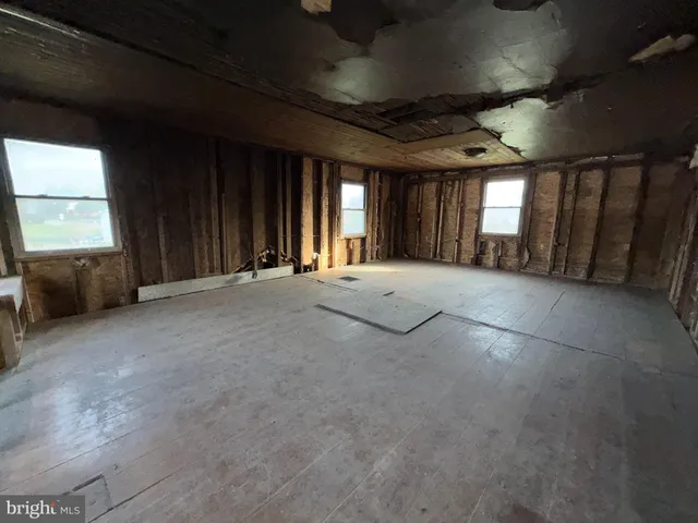 a view of an empty room with a fireplace and a window