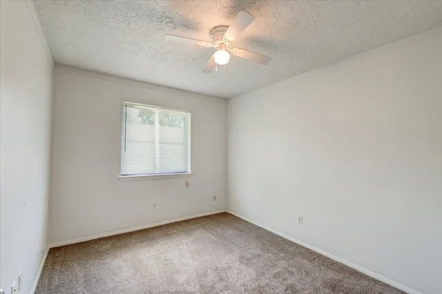 an empty room with closet and a chandelier fan