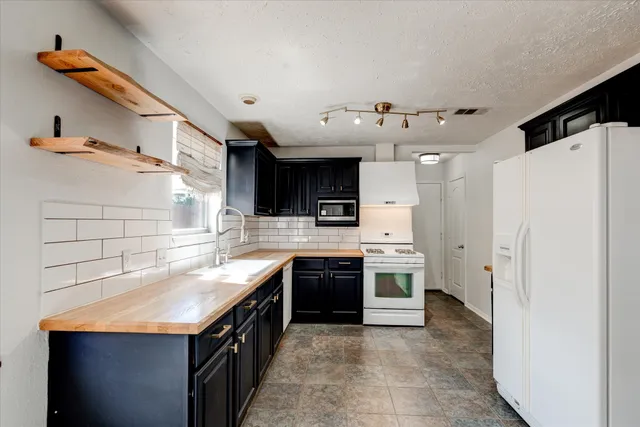 a kitchen with stainless steel appliances a sink and a refrigerator
