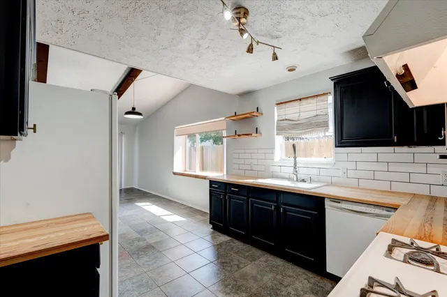 a kitchen with granite countertop a sink and a stove