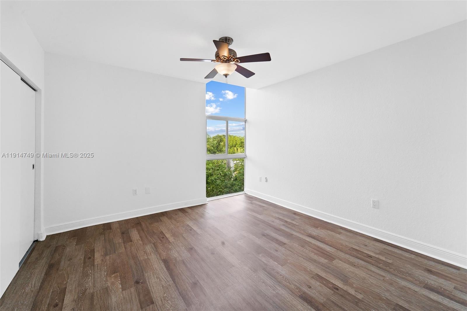 8041 Harding Avenue, Unit 105 Miami Beach, FL 33141 - Photo 11 of 23 a view of empty room with wooden floor ceiling fan and window