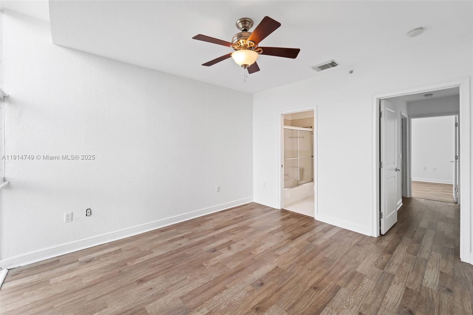 8041 Harding Avenue, Unit 105 Miami Beach, FL 33141 - Photo 12 of 23 an empty room with wooden floor and ceiling fan
