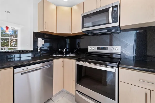 a kitchen with granite countertop a stove microwave and sink