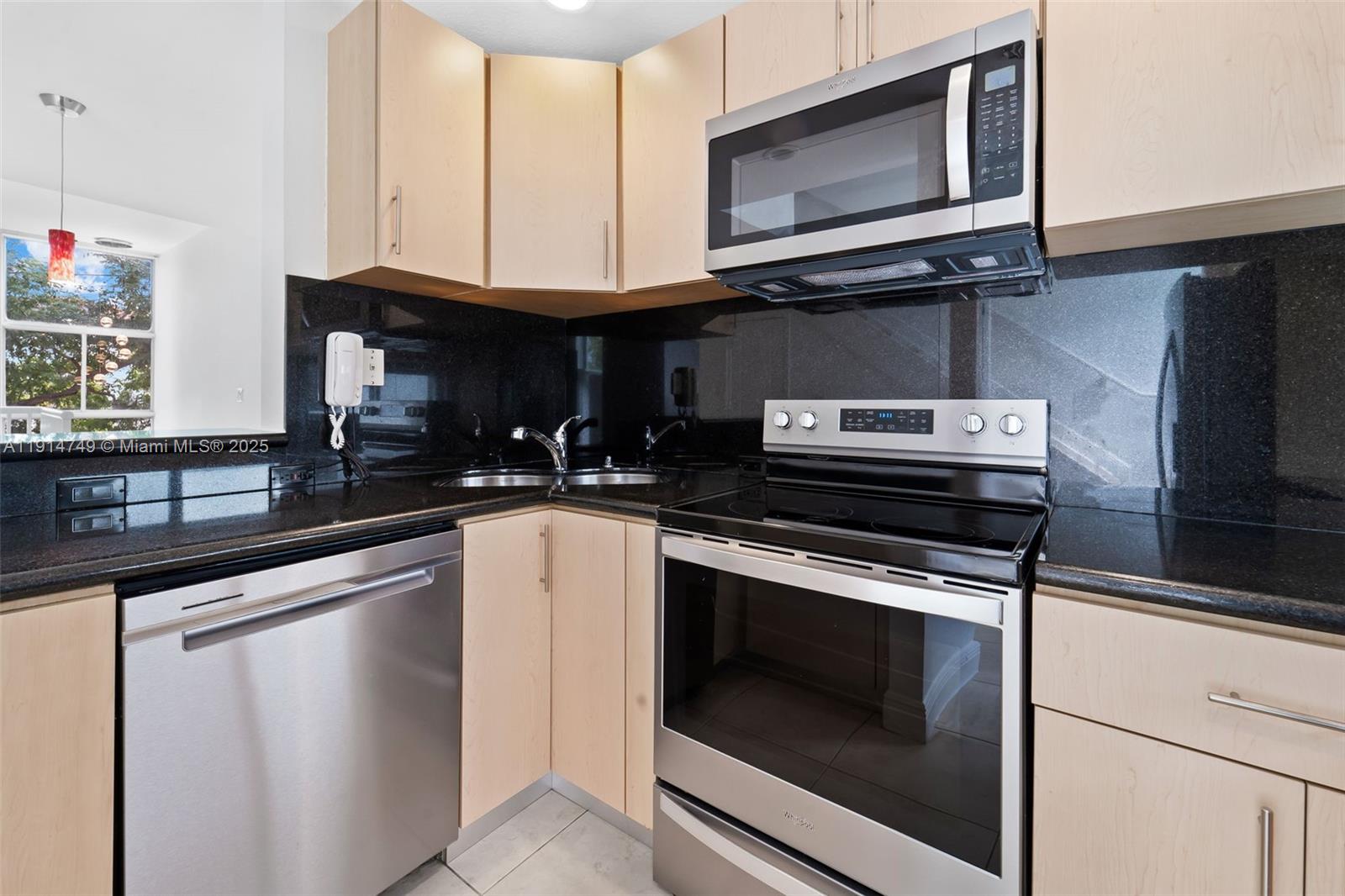 8041 Harding Avenue, Unit 105 Miami Beach, FL 33141 - Photo 9 of 23 a kitchen with granite countertop a stove microwave and sink