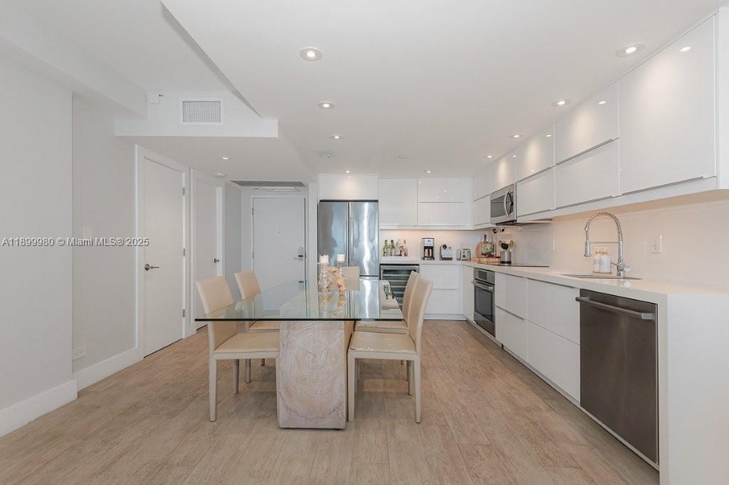 2301 Collins Avenue, Unit 738 Miami Beach, FL 33139 - Photo 15 of 33 a kitchen with white cabinets and stainless steel appliances