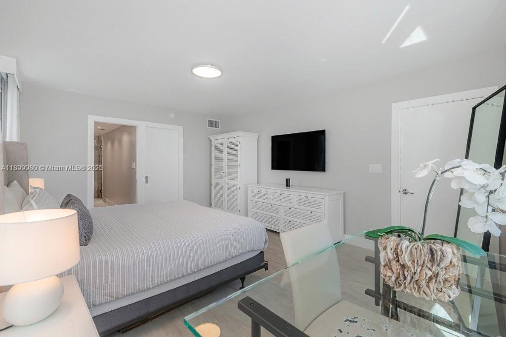 2301 Collins Avenue, Unit 738 Miami Beach, FL 33139 - Photo 22 of 33 a bedroom with a bed and a flat screen tv