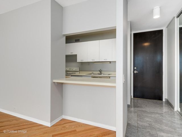 a view of kitchen with granite countertop cabinets and refrigerator