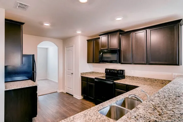 a kitchen with granite countertop stainless steel appliances and sink