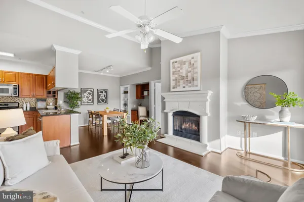 a living room with furniture a fireplace and kitchen view