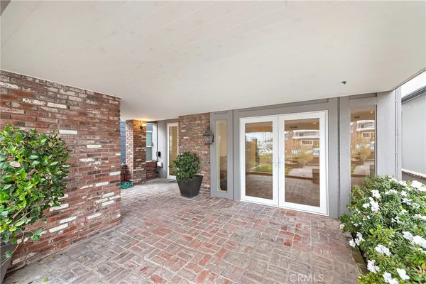 a view of an entrance to house with yard and glass windows