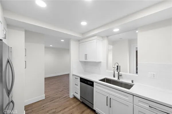 a kitchen with a sink a refrigerator and cabinets