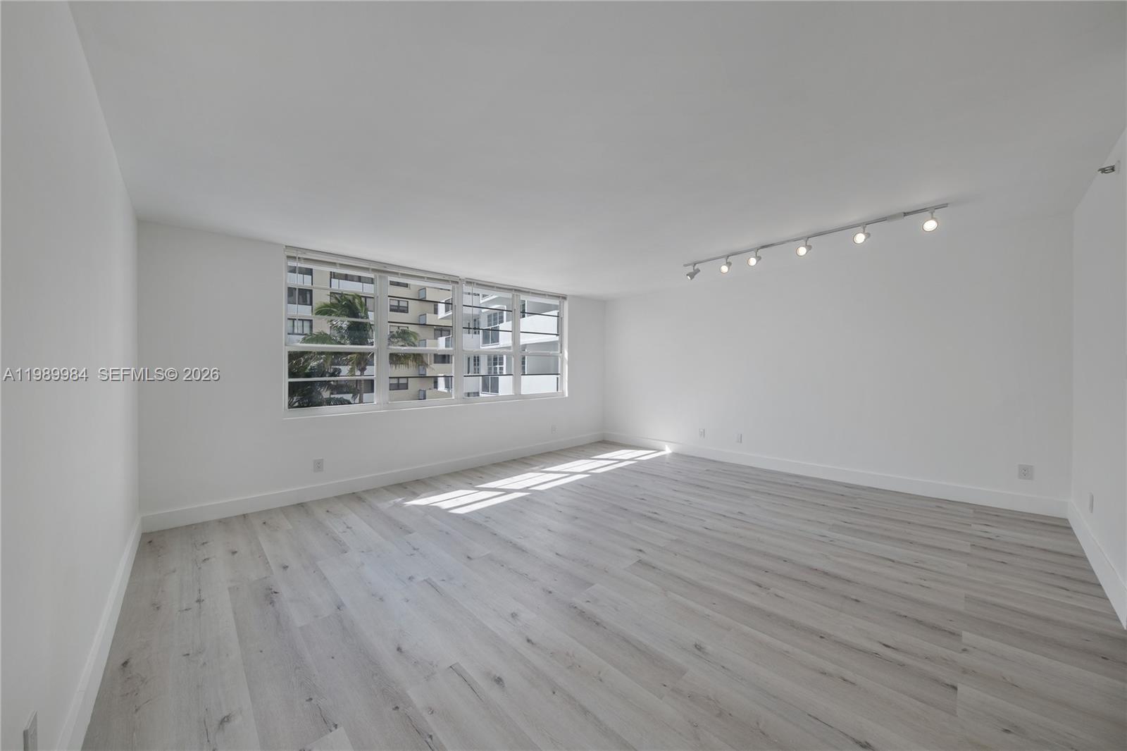 100 Lincoln Road, Unit 626 Miami Beach, FL 33139 - Photo 4 of 12 an empty room with wooden floor and windows