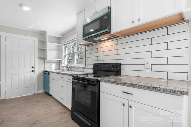 a kitchen with stainless steel appliances granite countertop a sink stove and microwave
