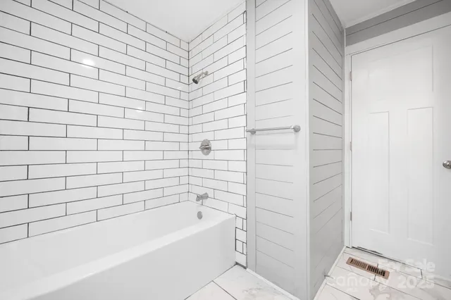 a bathroom with a bathtub and shower